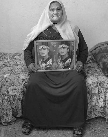La m�re de Wafa Idris, premi�re femme kamikaze palestinienne, posant chez elle, dans la banlieue de Ramallah, avec des photos de sa fille.  | MORGANE VARGAS LLOSA